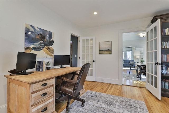 home office featuring french doors, light wood-style flooring, and baseboards