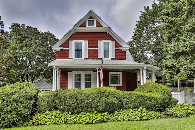 view of front facade with covered porch and fence