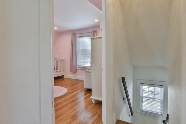 interior space featuring light wood-type flooring, baseboards, an upstairs landing, and recessed lighting