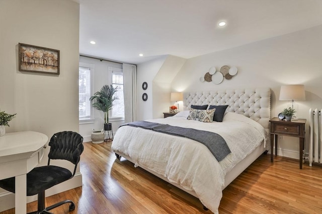 bedroom with recessed lighting, radiator heating unit, and wood finished floors