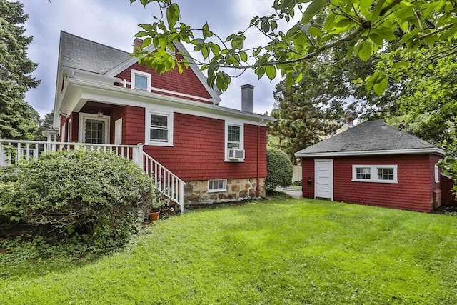 back of property with cooling unit, a lawn, a chimney, and an outdoor structure