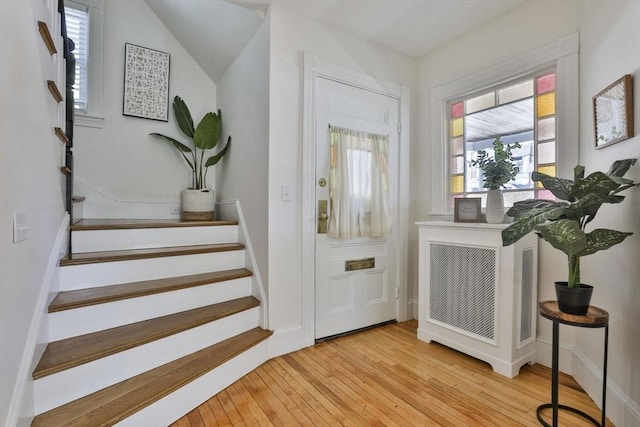 doorway featuring light wood-style flooring, visible vents, and stairway