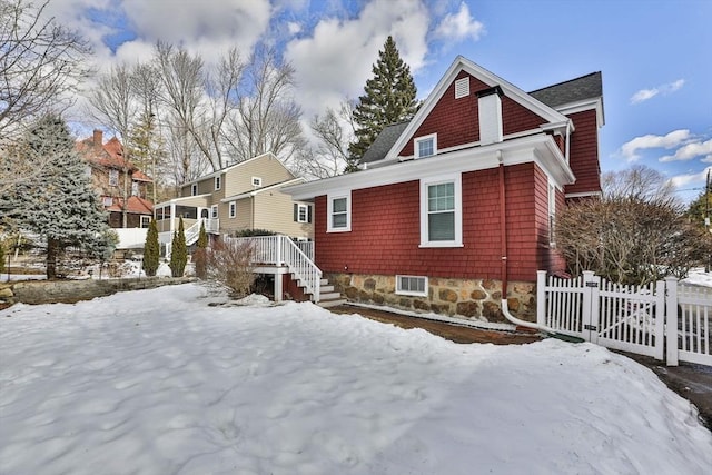 snow covered property featuring fence and a deck