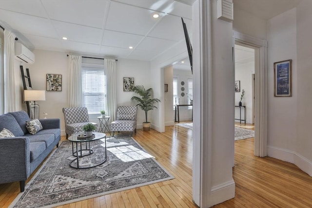 living room with light wood finished floors, a wall mounted AC, recessed lighting, and baseboards