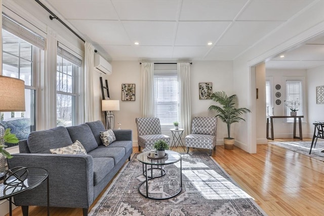 living area featuring a wall mounted AC, recessed lighting, wood finished floors, and baseboards