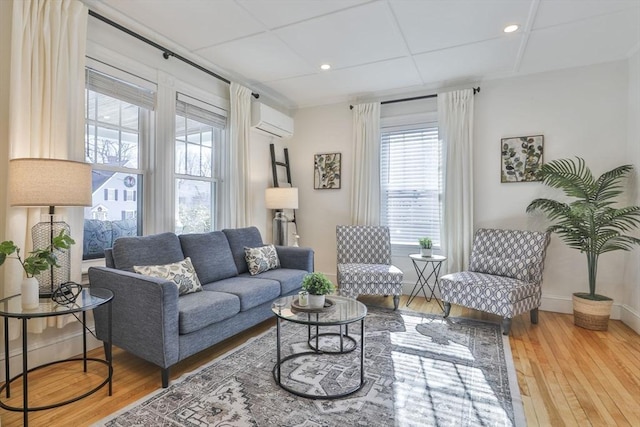 living room featuring recessed lighting, baseboards, hardwood / wood-style floors, and a wall mounted AC