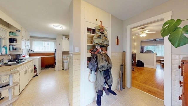 142 Dale St, Waltham, MA 02451 - hallway featuring a sink, plenty of natural light, light tile patterned floors, tile walls, and independent washer and dryer