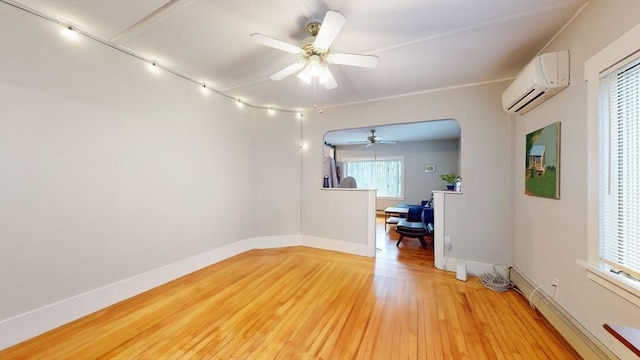 142 Dale St, Waltham, MA 02451 - empty room featuring a wall mounted air conditioner, ceiling fan, light wood-type flooring, baseboards, and baseboard heating