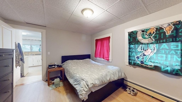 142 Dale St, Waltham, MA 02451 - bedroom featuring a baseboard radiator, wood finished floors, and a paneled ceiling
