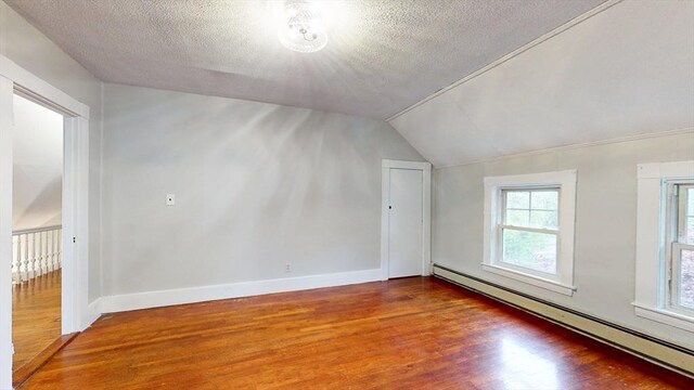 142 Dale St, Waltham, MA 02451 - additional living space featuring a baseboard radiator, wood finished floors, vaulted ceiling, a textured ceiling, and baseboards