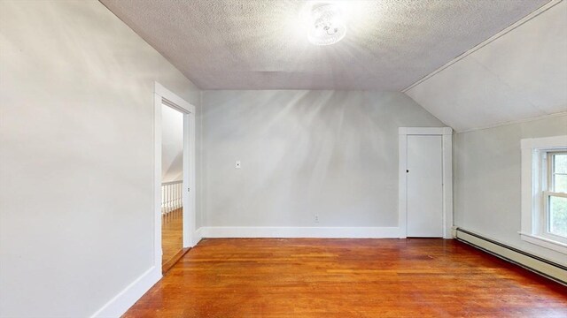 142 Dale St, Waltham, MA 02451 - additional living space with wood finished floors, baseboard heating, a textured ceiling, baseboards, and lofted ceiling