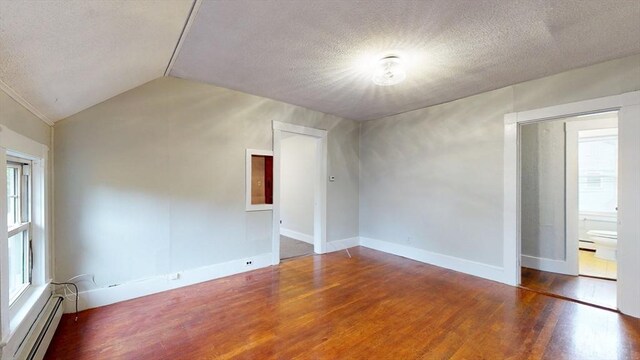 142 Dale St, Waltham, MA 02451 - unfurnished room featuring baseboard heating, lofted ceiling, wood finished floors, a textured ceiling, and baseboards