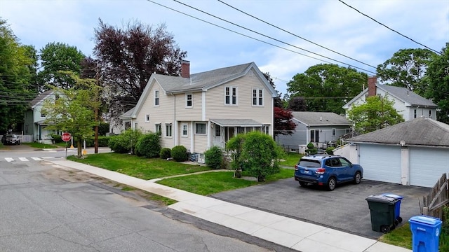 142 Dale St, Waltham, MA 02451 - view of front of house featuring an outbuilding, a front yard, a chimney, and a garage