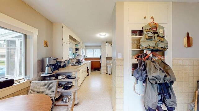 142 Dale St, Waltham, MA 02451 - kitchen featuring a sink, tile walls, wainscoting, and light countertops
