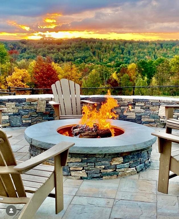 143 Clemence Hill Rd, Southbridge, MA 01550 - patio terrace at dusk with a fire pit and a wooded view