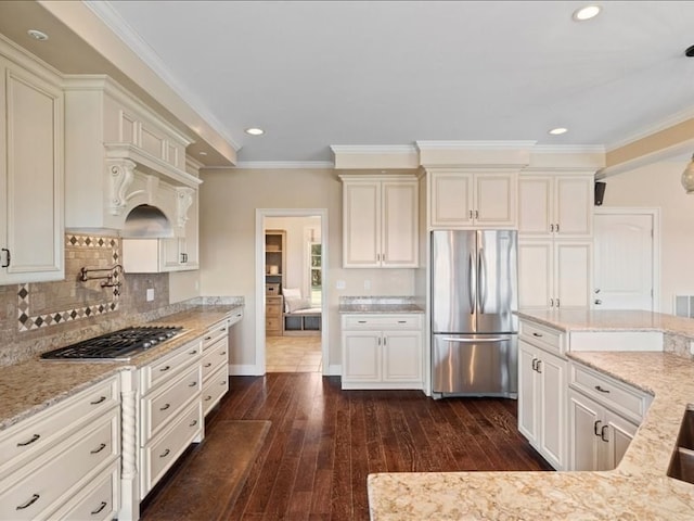 kitchen featuring light stone countertops, appliances with stainless steel finishes, dark hardwood / wood-style flooring, crown molding, and decorative backsplash