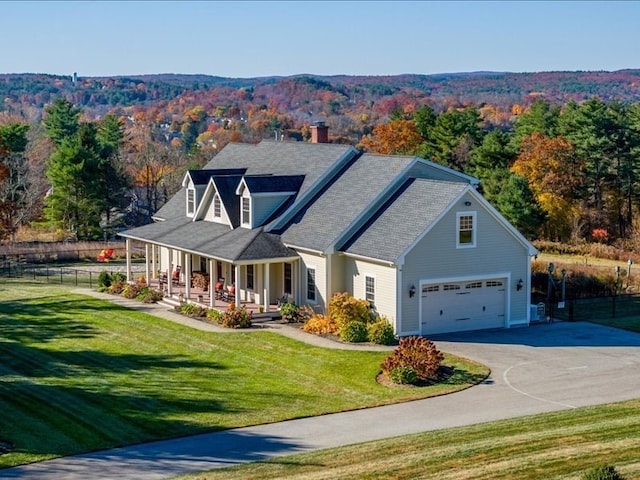 view of front of home with a porch, a front lawn, and a garage