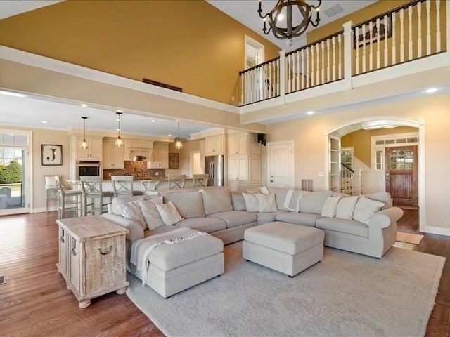 143 Clemence Hill Rd, Southbridge, MA 01550 - living area with a towering ceiling, a chandelier, wood finished floors, arched walkways, and baseboards