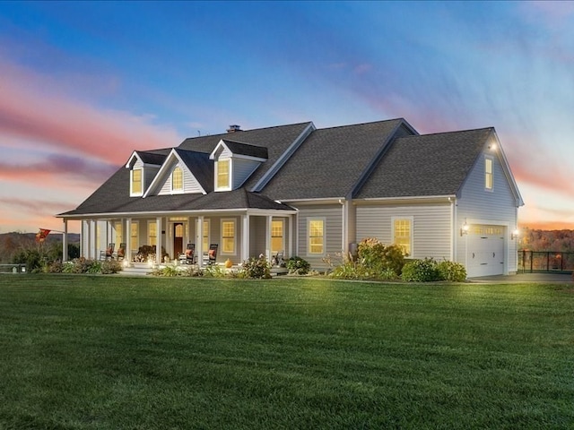 back house at dusk featuring covered porch, a lawn, and a garage