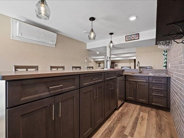 143 Clemence Hill Rd, Southbridge, MA 01550 - kitchen featuring a sink, dark brown cabinets, an AC wall unit, light wood-style flooring, and decorative light fixtures