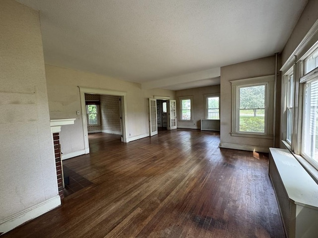 117 Rogers, West Springfield, MA 01089 - unfurnished living room with wood finished floors, a brick fireplace, and radiator
