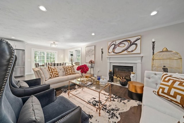 living room with hardwood / wood-style floors, ornamental molding, and a premium fireplace