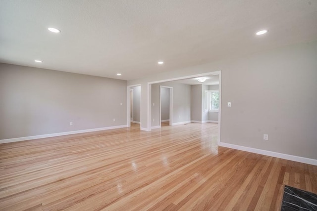 unfurnished room with light wood-style floors, baseboards, and recessed lighting