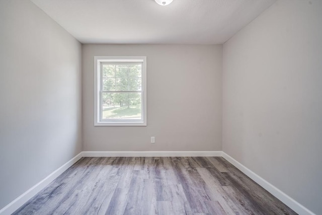 unfurnished room with baseboards and wood finished floors