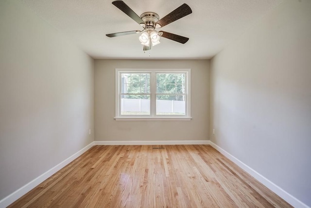 unfurnished room featuring light wood-style floors, baseboards, and a ceiling fan