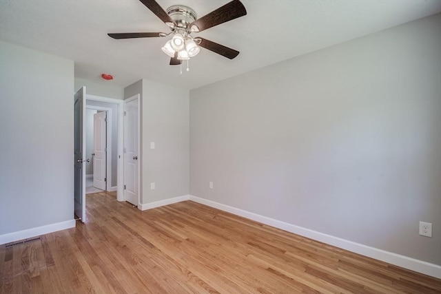 empty room with baseboards, ceiling fan, visible vents, and light wood-style floors