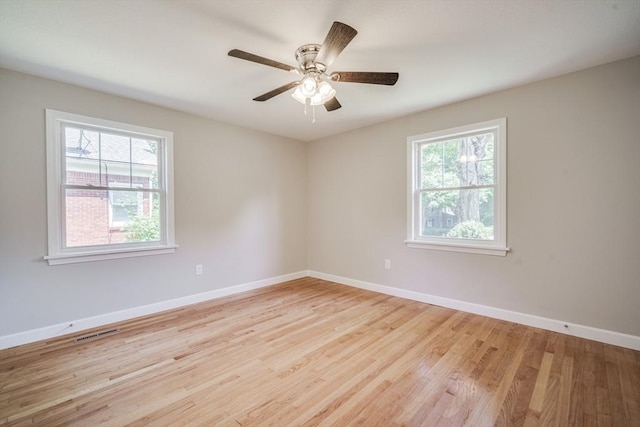 unfurnished room with baseboards, visible vents, plenty of natural light, and light wood finished floors