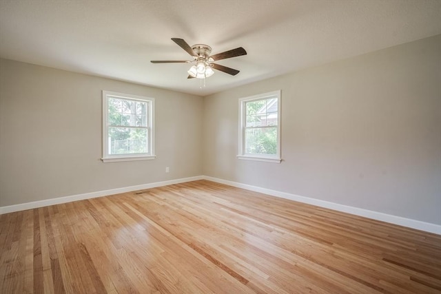 spare room with light wood-style floors, ceiling fan, and baseboards