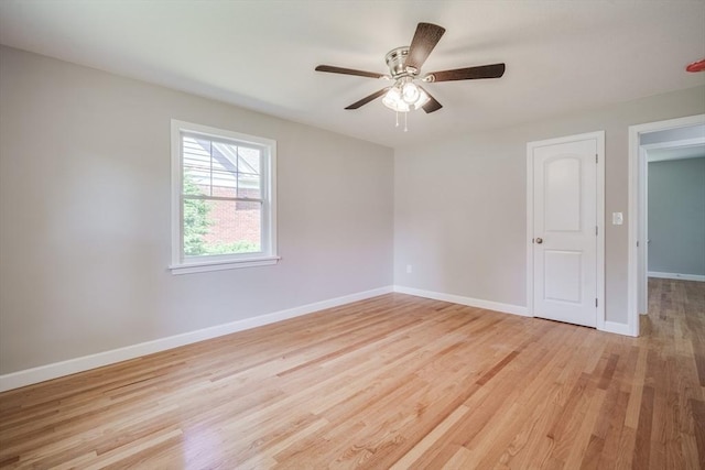 empty room with light wood-type flooring, ceiling fan, and baseboards