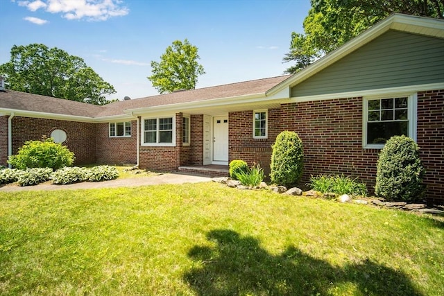 ranch-style house featuring a front yard and brick siding