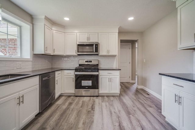 kitchen with white cabinets, light wood finished floors, and stainless steel appliances