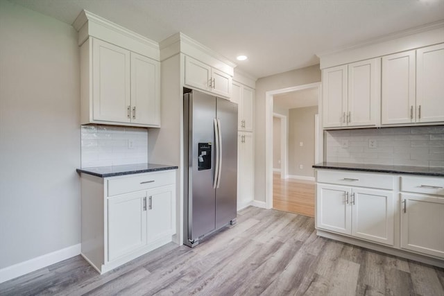 kitchen featuring light wood-type flooring, baseboards, backsplash, and stainless steel fridge with ice dispenser