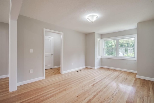 empty room with light wood-style flooring and baseboards