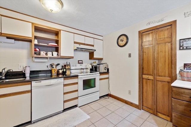 kitchen featuring light tile patterned flooring, tasteful backsplash, sink, white cabinets, and white appliances