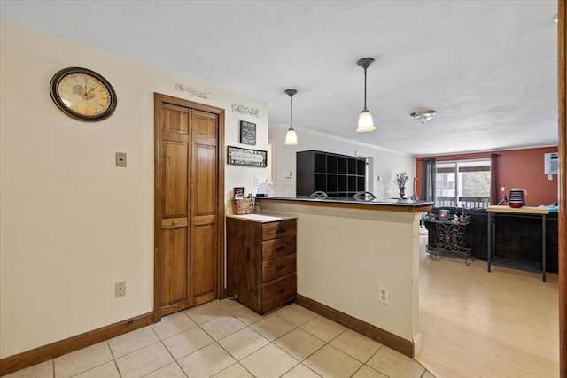 kitchen with light tile patterned flooring, pendant lighting, and kitchen peninsula