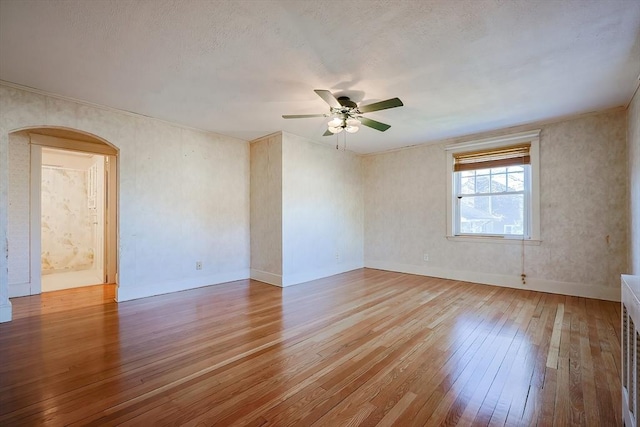 spare room with ceiling fan, light hardwood / wood-style floors, and a textured ceiling