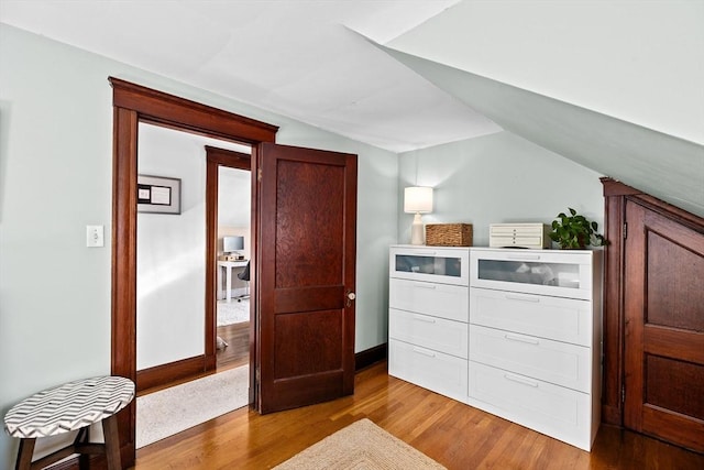 bedroom featuring light wood-type flooring and lofted ceiling