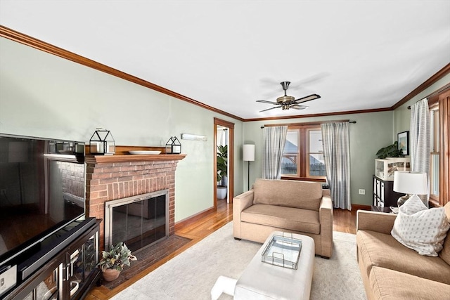 living room featuring ceiling fan, ornamental molding, a brick fireplace, and hardwood / wood-style floors