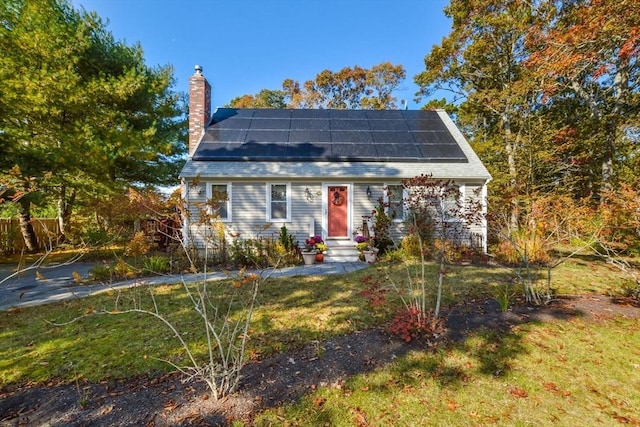 view of front of property featuring roof mounted solar panels and a chimney