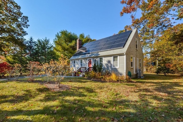 exterior space featuring solar panels, a lawn, roof with shingles, and a chimney