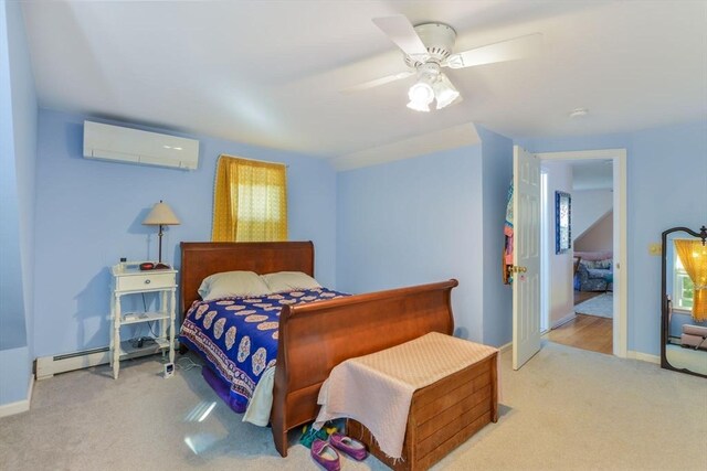 bedroom featuring a ceiling fan, baseboards, carpet floors, a wall mounted air conditioner, and a baseboard heating unit