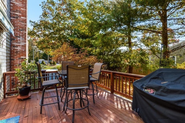 deck with a grill and outdoor dining area