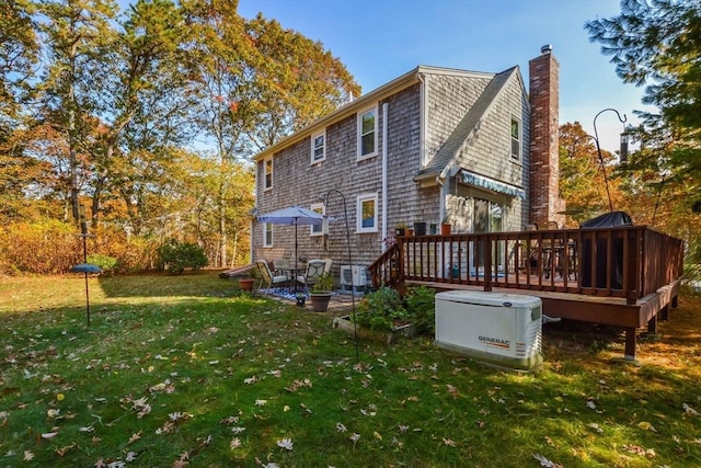 rear view of property featuring a wooden deck, central AC, a chimney, and a yard