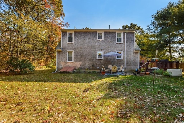 back of property featuring a yard and a wooden deck