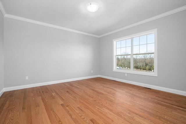 unfurnished room with light wood finished floors, baseboards, and crown molding