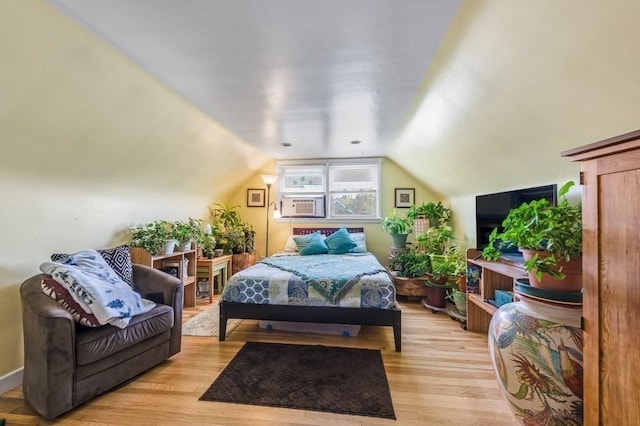 bedroom featuring light wood-style floors and vaulted ceiling